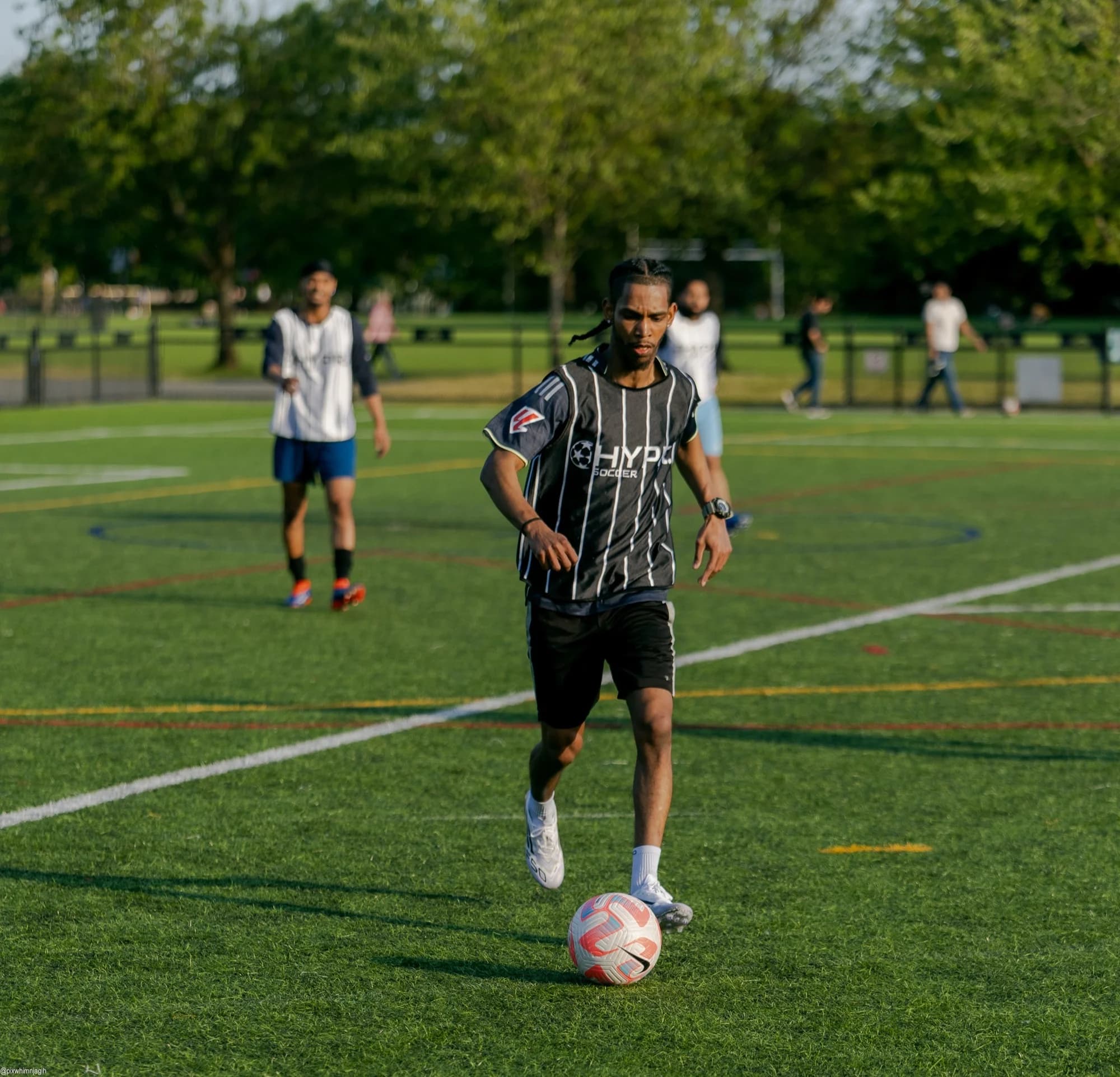 HYPR Soccer player dribbling past defenders during outdoor match in Vancouver - Njagih Studios