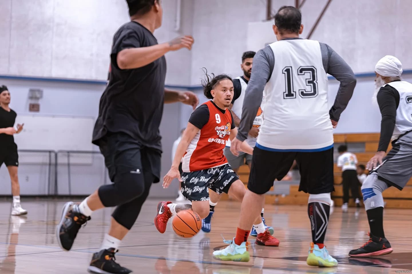 Indoor basketball league game with player dribbling through defenders in Vancouver - Njagih Studios sports photography