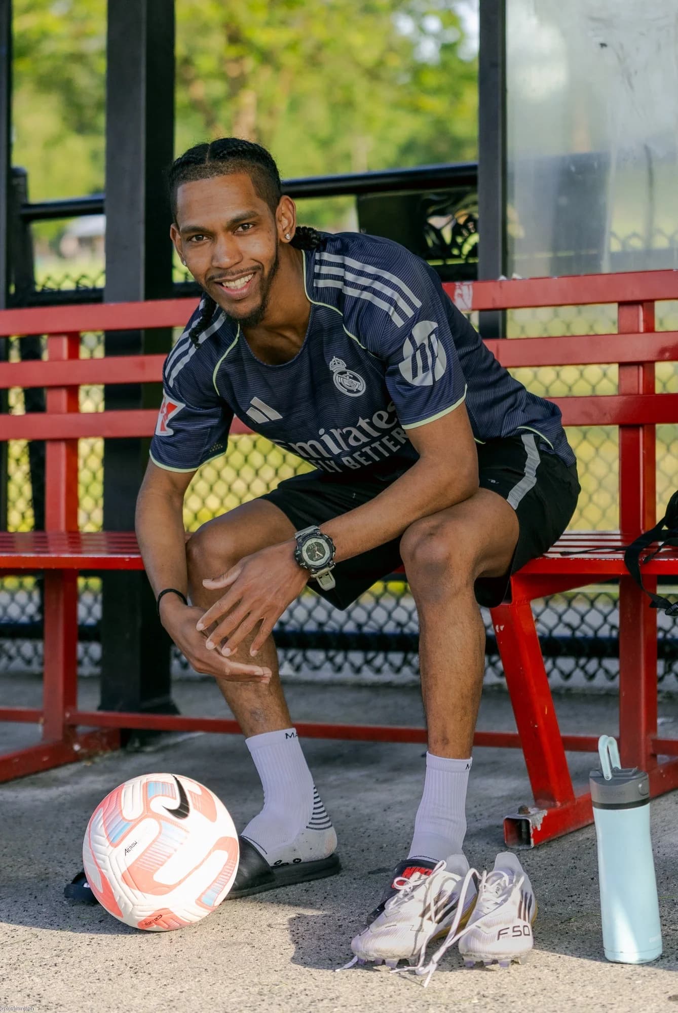 Soccer player portrait sitting on bench with ball and cleats in Vancouver - Njagih Studios portrait photography