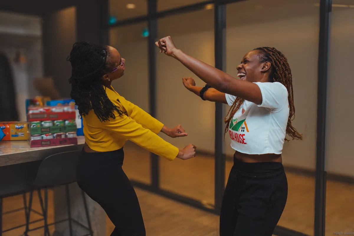 Two women dancing and laughing at indoor social event - Njagih Studios event lifestyle photography