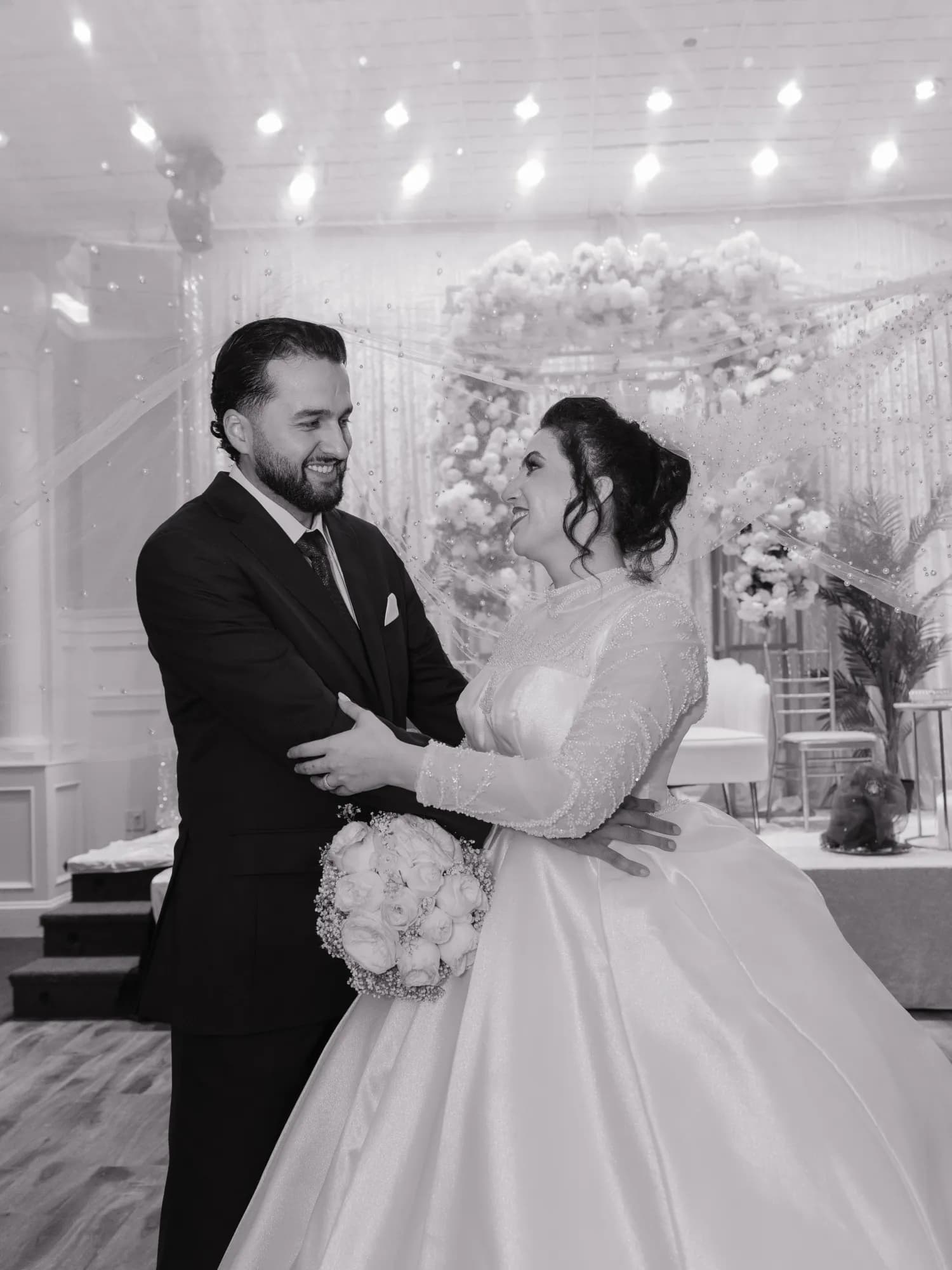 Black and white wedding portrait of couple dancing at decorated reception venue - Njagih Studios wedding photography