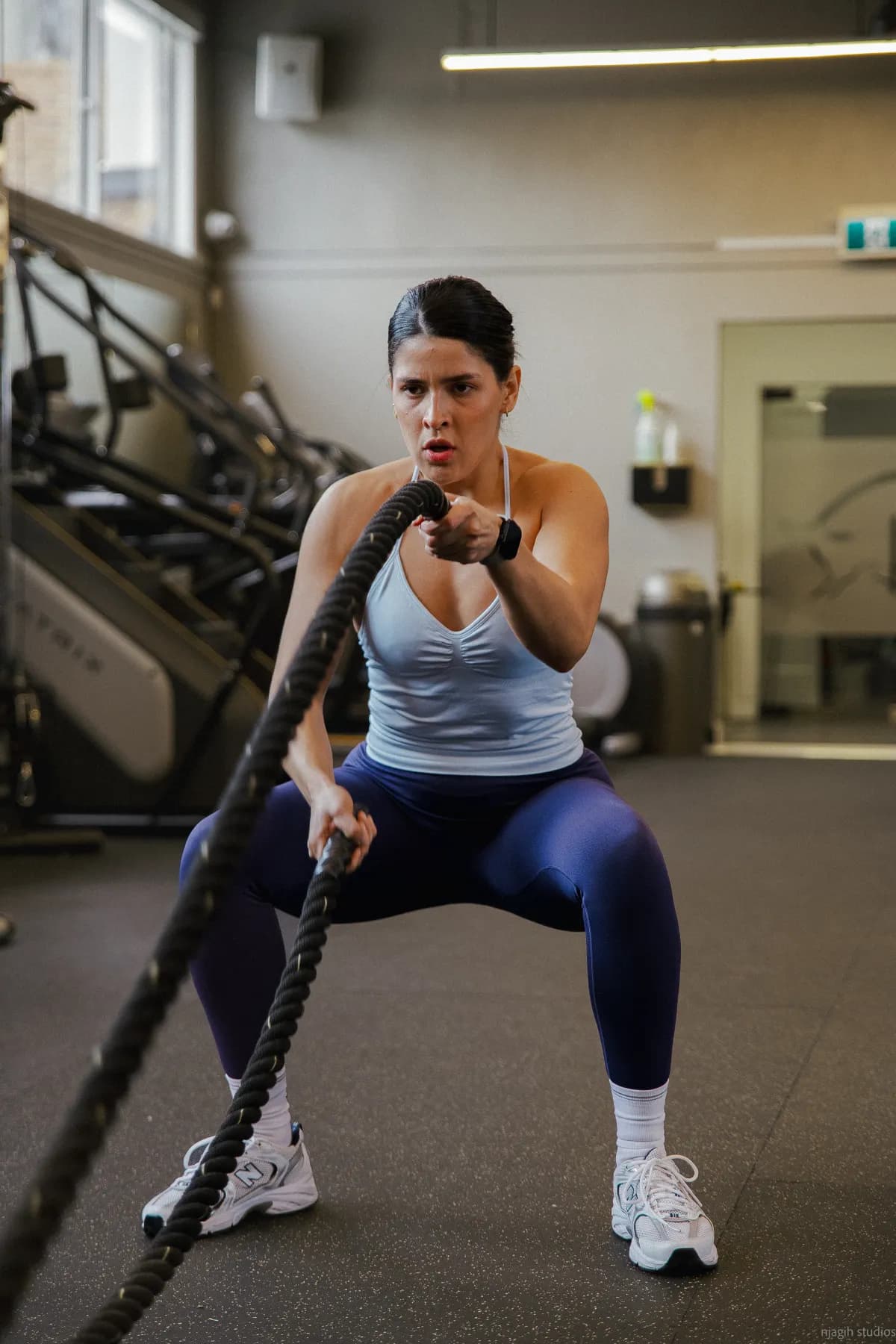Woman training with battle ropes during gym workout - Njagih Studios professional photography services