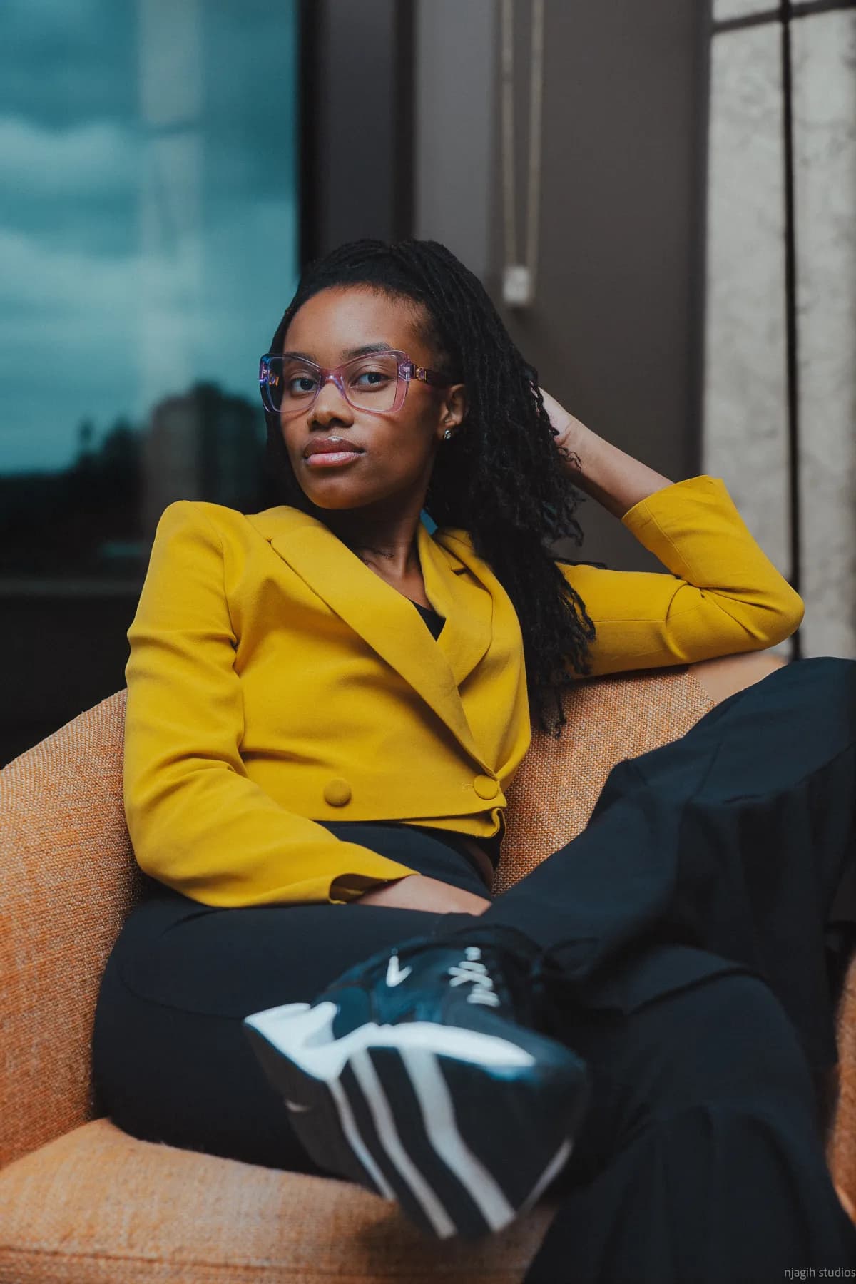 Woman in yellow blazer seated in armchair for editorial portrait session - Njagih Studios fashion photography Vancouver