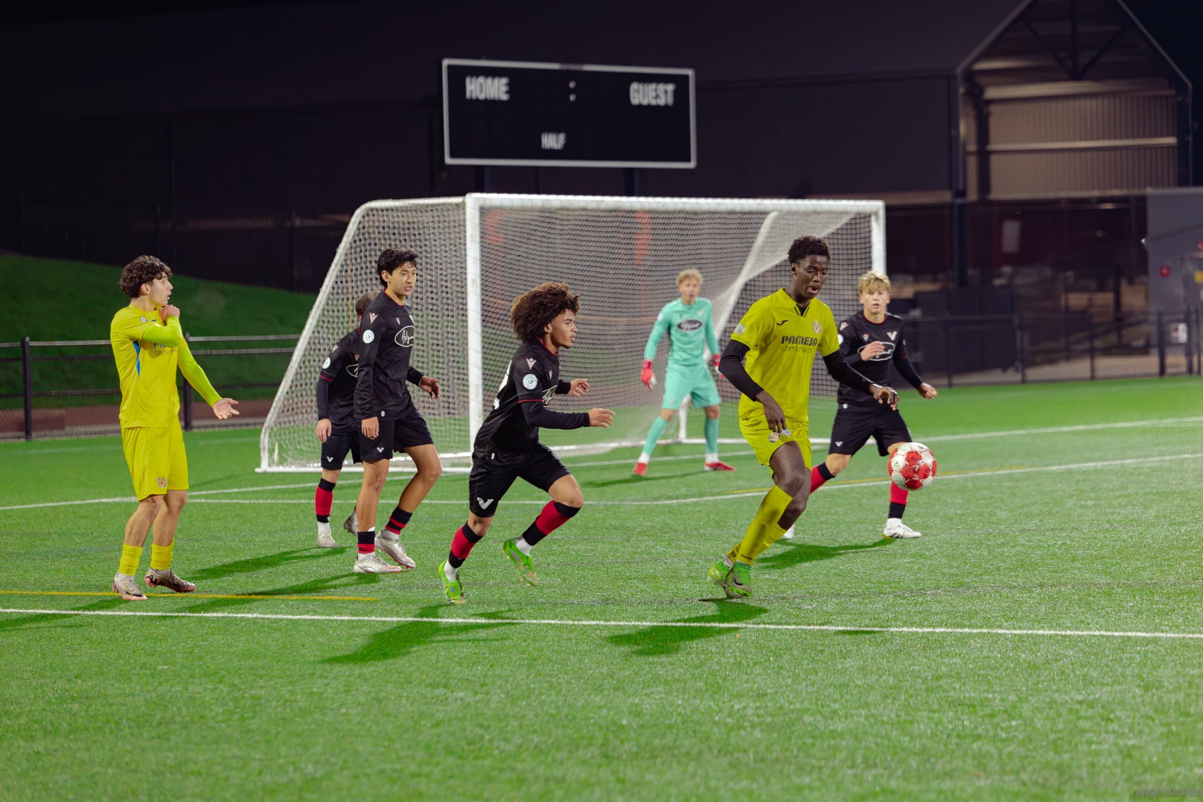 Soccer players in action during a night game